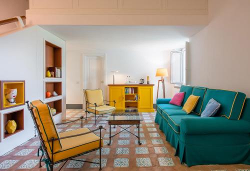 a living room with a blue couch and two chairs at Relais Regina Giovanna in Sorrento
