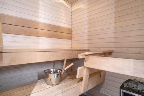 a sauna with wooden walls and a bucket in it at Loimu in Rovaniemi
