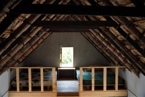 a attic room with two beds and a window at Pousada Dragoeiro Monte Joana Santo Antão in Ribeira Grande