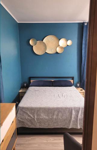 une chambre avec un lit et un mur bleu dans l'établissement Le Bel Air - Central avec Climatisation & Parking, à Gréoux-les-Bains