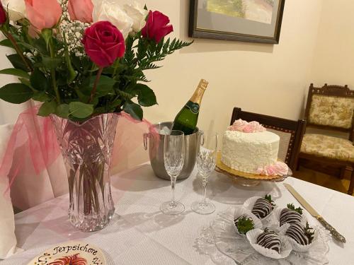 a table with a bottle of champagne and a cake and flowers at Cajun-Get Away in Breaux Bridge