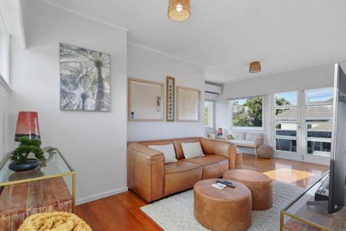 a living room with a couch and a table at Amazing Home By Beach - Fully Aircon-ed - Wifi in Auckland