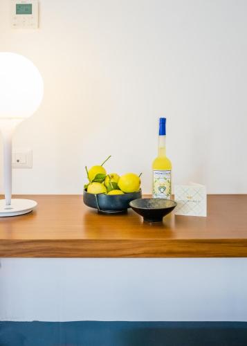 a bottle of wine and a bowl of lemons on a table at Relais Regina Giovanna in Sorrento