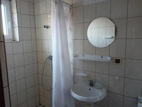 een witte badkamer met een wastafel en een spiegel bij Willa Rosa in Kajetany