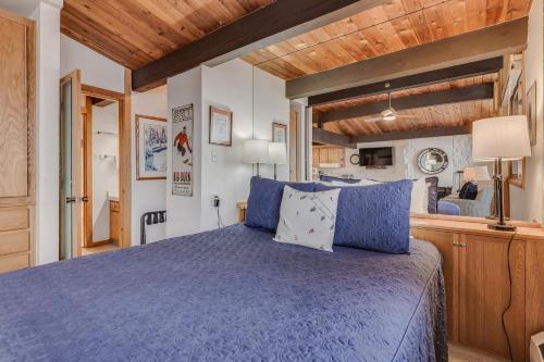 a bedroom with a blue bed and a kitchen at Laurelwood Condominiums 112 in Snowmass Village