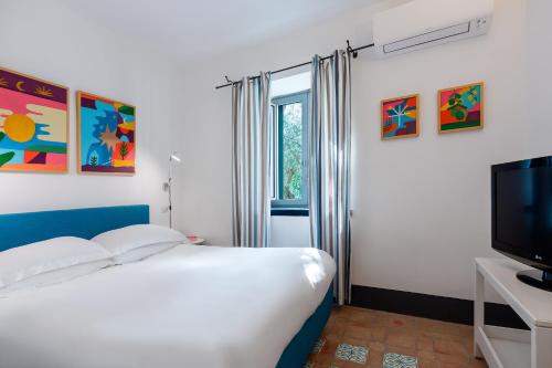 a bedroom with a bed and a flat screen tv at Relais Regina Giovanna in Sorrento