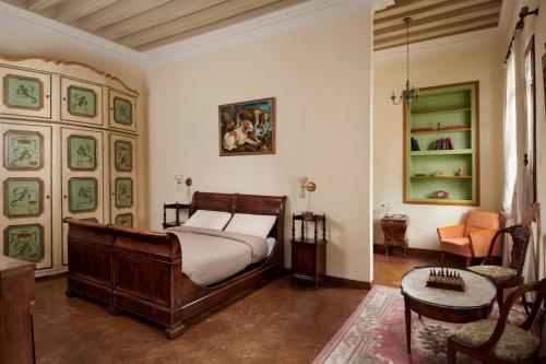una camera con letto, sedia e tavolo di Villa Stecchini a Bassano del Grappa