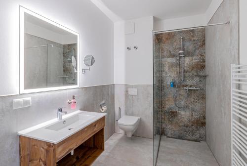 een badkamer met een wastafel, een toilet en een douche bij Sporthotel Neuruppin - Apartmenthaus mit Ferienwohnungen in Neuruppin