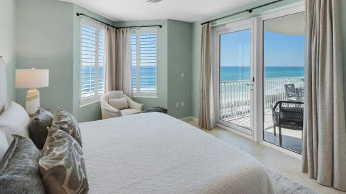 a bedroom with a bed and a balcony with the ocean at Tranquillity 340 in Panama City Beach