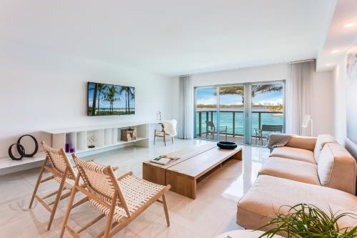 a living room with a couch and a table and chairs at Beach Haus Bal Harbour in Miami Beach
