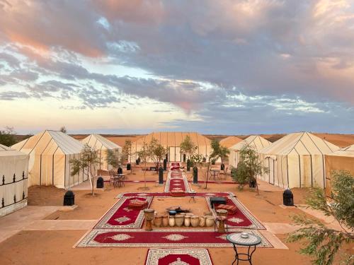 a view of a mosque with a fountain and tents at Your Family Camp in Merzouga