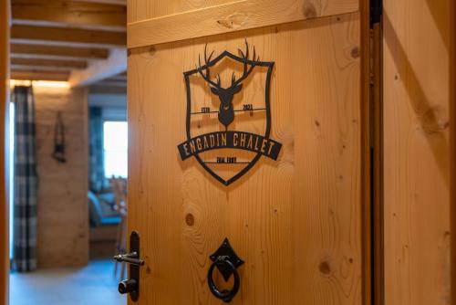 a sign on a wooden wall with a deer on it at Engadin Chalet - Private Spa Retreat & Appart -St Moritz - Val Bever in Bever
