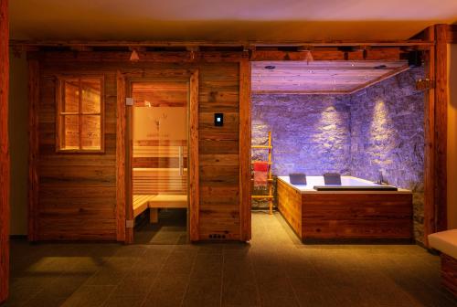 a room with a bed and a wooden wall at Engadin Chalet - Private Spa Retreat & Appart -St Moritz - Val Bever in Bever