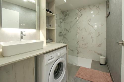 a bathroom with a washing machine and a sink at Royal Apartment Las Américas near the beach in Playa Fañabe