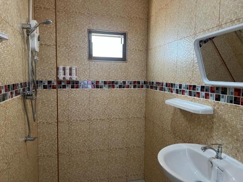 La salle de bains est pourvue d'un lavabo et d'une douche. dans l'établissement Golf House, à Ban Bang Phai