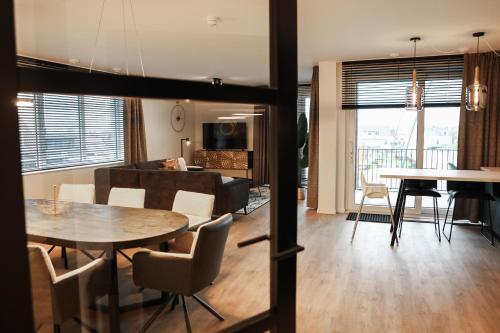 a living room and dining room with a table at Luxe loft appartement in Résidence Marina Kamperland (8 pers.) in Kamperland