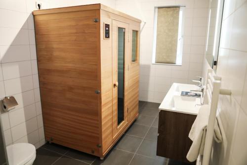 a bathroom with a wooden shower and a sink at Luxe loft appartement in Résidence Marina Kamperland (8 pers.) in Kamperland