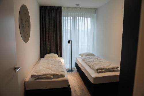 Habitación con 2 camas y reloj en la pared en Luxe loft appartement in Résidence Marina Kamperland (8 pers.), en Kamperland