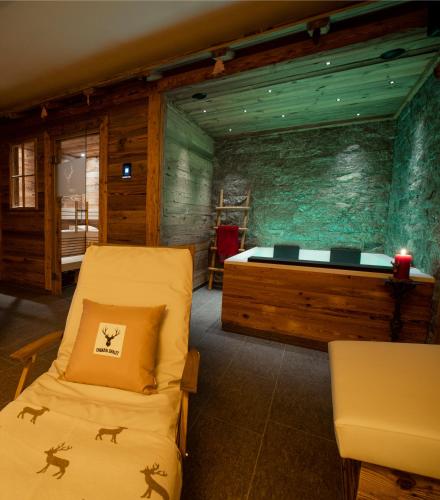 a bedroom with two beds and a stone wall at Engadin Chalet - Private Spa Retreat & Appart -St Moritz - Val Bever in Bever