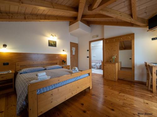 sypialnia z dużym łóżkiem w pokoju z drewnianą podłogą w obiekcie Agritur Widmann w mieście Coredo