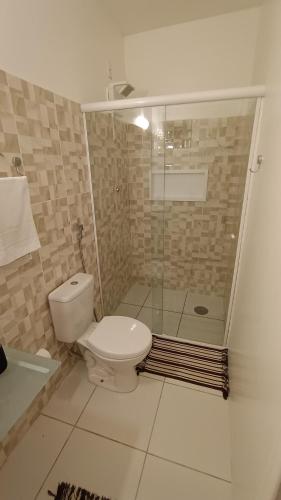 a bathroom with a toilet and a glass shower at Suíte Próxima a Praias! in São Luís