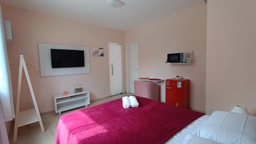 a bedroom with a red bed and a red refrigerator at Suíte Próxima a Praias! in São Luís