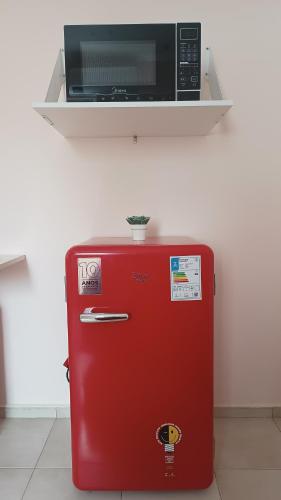 a red refrigerator with a microwave on top of it at Suíte Próxima a Praias! in São Luís
