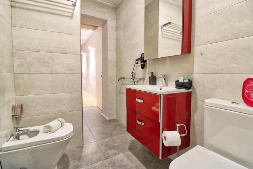 baño con aseo blanco y armario rojo en Lujoso apartamento en el centro de la ciudad en Murcia