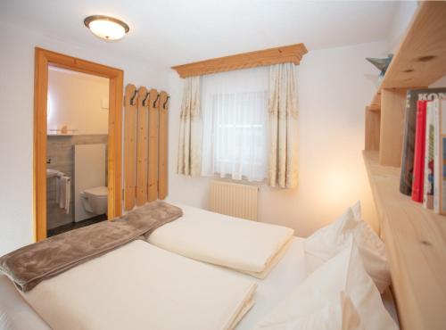 a small bedroom with a bed and a window at Ferienwohnungen Wolf in Holzgau