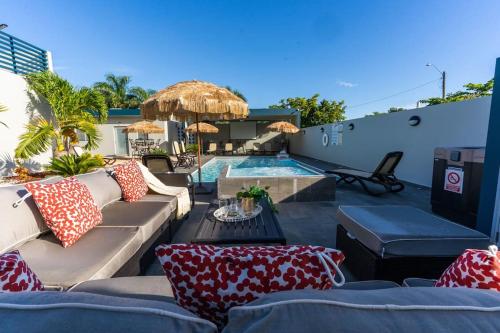 un patio con sofá y piscina en Aquaville Dorado Moderna Villa 5 en Dorado