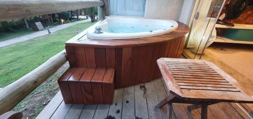 a bath tub sitting on a deck with a bench at Villas do Pratagy resort Maceió próximo praia in Maceió