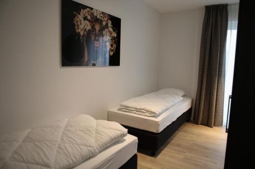two beds in a room with a picture on the wall at Luxe en comfortabel appartement aan het water in Kamperland