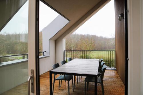 a dining room with a table and chairs on a balcony at Luxe en comfortabel appartement aan het water in Kamperland