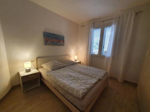 ein Schlafzimmer mit einem Bett und zwei Nachttischen in der Unterkunft Gemütliche neue Ferienwohnung in La Ciaccia in Codaruina