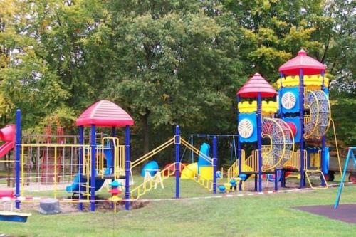 un parque con un parque infantil con toboganes y toboganes coloridos en Statige boerderijwoning met vrij uitzicht en tuin, en Hoogzand