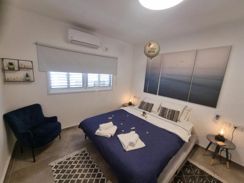 a bedroom with a large bed and a blue chair at Beautiful 2-Bedroom Sea-View apartment in Netanya
