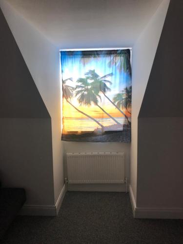 a room with a painting of palm trees on the wall at Baywatch, Shannon River View in Droíchead an Chláir