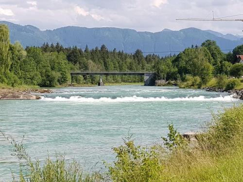 a bridge over a river with waves in the water at Casa Cubana - Schönes und komfortables Ferienhaus am Waldrand in Lechbruck