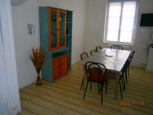 une salle à manger avec une table, des chaises et une armoire dans l'établissement Maison proche de la plage, à Fécamp