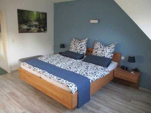 a bedroom with a large bed with blue walls at Ferienwohnung Ganz Oben, Stadtmitte Hermeskeil in Hermeskeil