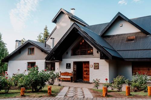 a white house with a black roof at Basia Hotel & Sushi in San Carlos de Bariloche