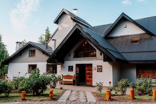 uma casa branca com um telhado preto em Basia Hotel & Sushi em San Carlos de Bariloche