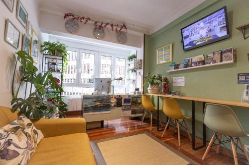 een kamer met een bar met stoelen en een tafel bij Pension Angelines, Sneuu Hostel Santander in Santander