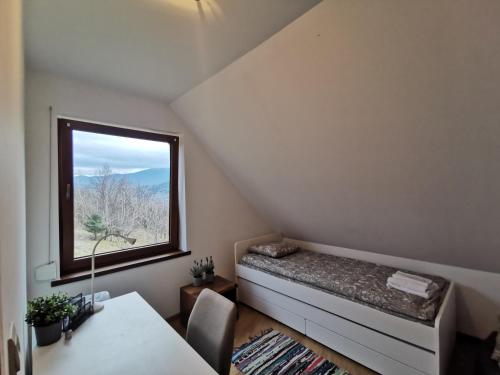 ザボヤにあるDomek na Niedźwiedziarceのベッドと窓が備わる小さな客室です。