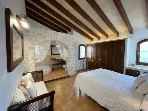 a bedroom with a bed and a bathroom with a tub at Villa Noray Cala Morell in Cala Morell