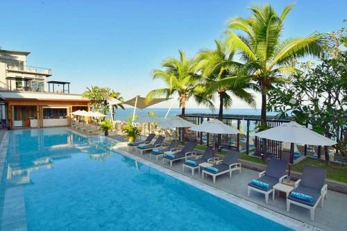 a large swimming pool with chairs and umbrellas at Cape Sienna Phuket Gourmet Hotel & Villas - SHA Extra Plus in Kamala Beach