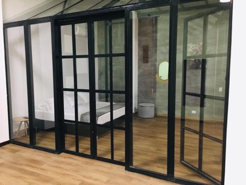a room with glass doors with a bed in it at Soy Local Primavera in Medellín