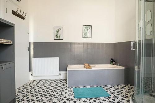 a bathroom with a tub and a tile floor at 4 bed home 3 mins from harbour + sandy beach in Kent
