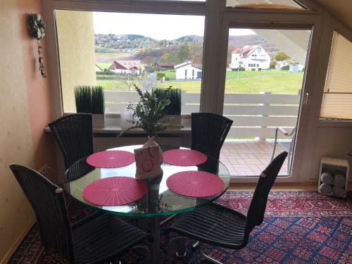 einen Esstisch mit rosa Sonnenschirmen darauf in der Unterkunft Fewo Seeresidenz auf Scheid in Waldeck