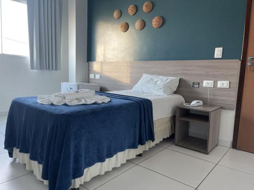 - une chambre avec un lit et une couverture bleue dans l'établissement Hotel Center Vitoria, à Vitória de Santo Antão